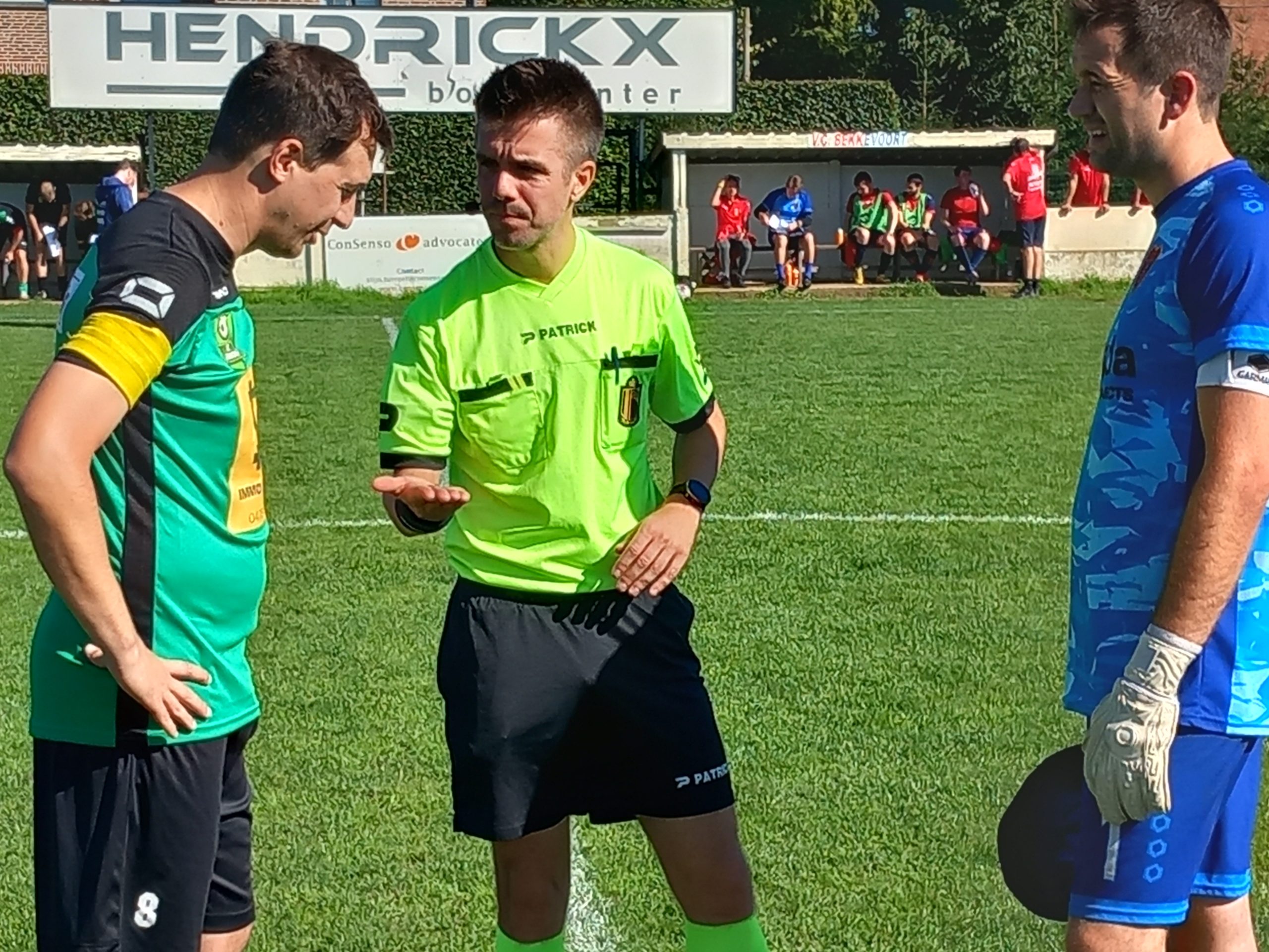 De toss met scheidsrechter Jan Vermeulen tussen kapiteins Vanderlinden (groen-FC Binkom) en Simons (blauw-VC Bekkevoort)